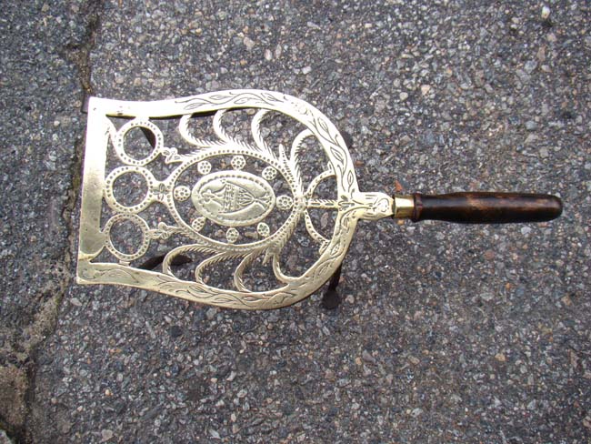 An attactive English 18th century engraved brass trivet on wrought iron feet circa 1780
